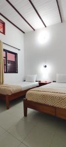 um quarto com duas camas e uma janela em HOTEL BUGANVILIA em Oiba