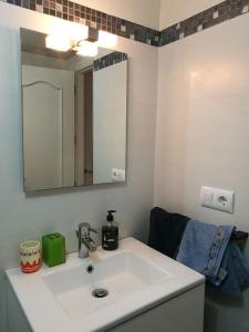uma casa de banho com um lavatório branco e um espelho. em Fantástico apartamento con vistas en Almerimar em Almerimar