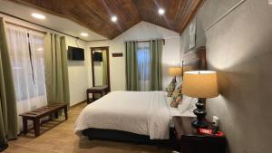 een slaapkamer met een bed, een lamp en een raam bij Camino Verde B&B Monteverde Costa Rica in Monteverde Costa Rica
