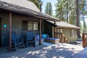 un porche de una casa con 2 sillas y un colchón en Whispering Pines en Flagstaff