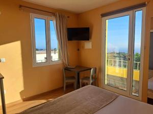 - une chambre avec un lit et un bureau avec une fenêtre dans l'établissement Calheta Countryside, à Calheta