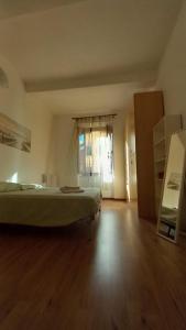 1 dormitorio con 1 cama y suelo de madera en L'Iris en Livorno