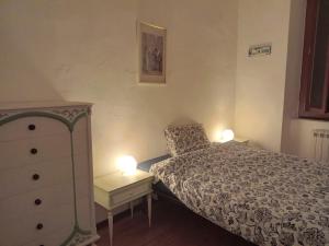 a bedroom with a bed and a dresser with two lamps at L'Iris in Livorno