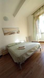 ein Schlafzimmer mit einem Bett in einem Zimmer mit einem Fenster in der Unterkunft L'Iris in Livorno