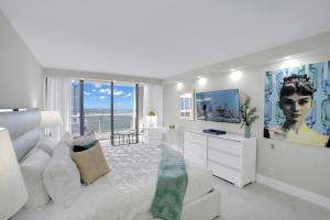 a white bedroom with a large bed and a large window at Superstar! Penthouse with Water and Park Views! in Miami