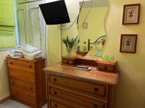 a room with a dresser with a mirror and a television at ApartBeach Wyliana in Candelaria
