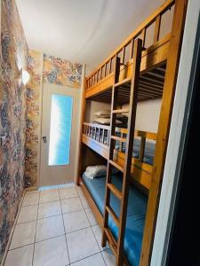 Cette chambre comprend 2 lits superposés et une porte. dans l'établissement Studio cosy 5 personnes, à Saint-Lary-Soulan