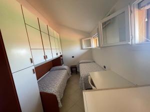 a small room with two beds and a kitchen at Villa con porticato sul prato in Isola Albarella