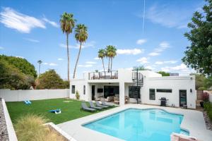a white house with a swimming pool and palm trees at Horizon Heights in Scottsdale