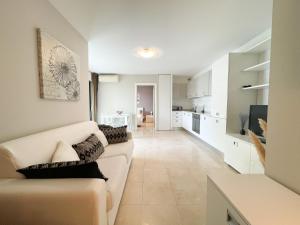 a living room with a couch and a kitchen at Deux pièces, parking et piscine in Beausoleil