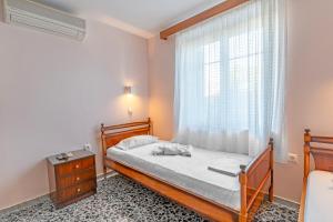 a bedroom with a bed and a window at La Skala Eressos Holiday Apartments in Skala Eresou