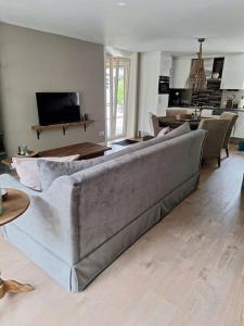 a living room with a large couch in a living room at Family Wellness lodge 4 personen Zuid-Holland! in Ooltgensplaat +25 photos