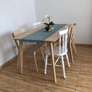 a wooden table with chairs and a table with a potted plant at Apartamento golf del sur in Santa Cruz de Tenerife