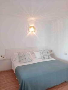 a bedroom with a bed with a light on the wall at Apartamento golf del sur in Santa Cruz de Tenerife