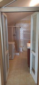 a bathroom with a shower and a sink and a washing machine at Villa con porticato sul prato in Isola Albarella