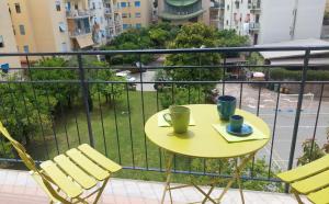 a yellow table with two cups and chairs on a balcony at CASA Eduardo e Titina in Sorrento