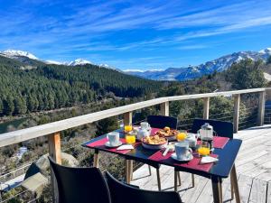 a table with food and drinks on a balcony with mountains at Terrazas de Meliquina in Villa Meliquina