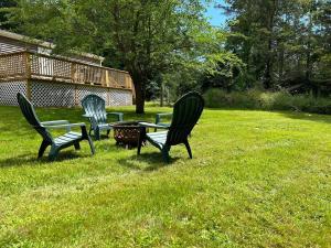 três cadeiras e uma mesa na relva em Tranquil Litchfield Retreat em Litchfield