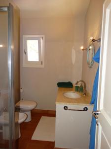 ein Bad mit einem Waschbecken, einem WC und einem Fenster in der Unterkunft Villa Gemma in Porto Azzurro