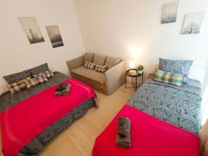 een woonkamer met 2 bedden en een bank bij By Plaza Universidad Rooms in Barcelona