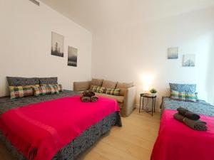 een slaapkamer met 2 bedden en een bank bij By Plaza Universidad Rooms in Barcelona