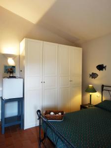a bedroom with a bed and white cabinets at Villa Gemma in Porto Azzurro