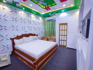 a bedroom with a bed and a tv on a wall at TOUR EIFFEL HÔTEL in Porto-Novo