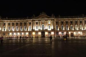 een groot gebouw 's nachts met mensen die er omheen lopen bij A 150 pas du Capitole! in Toulouse