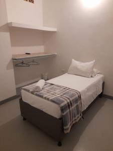 a small bedroom with a bed with a blanket at Aloja-T en Apartamento amoblado 3 Ciudad Bolivar in Ciudad Bolívar