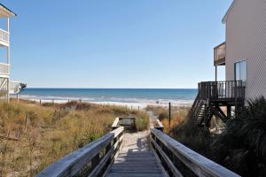 una escalera de madera que conduce a una playa con un edificio y el océano en Portside Resort by Panhandle Getaways, en Panama City Beach