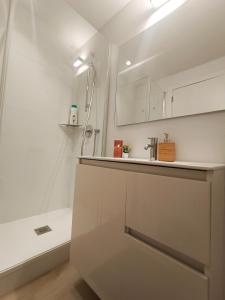 een witte badkamer met een wastafel en een douche bij By Plaza Universidad Rooms in Barcelona