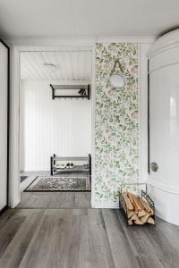 een woonkamer met een muur met bloemenbehang bij Gulliga torpet in Vislanda