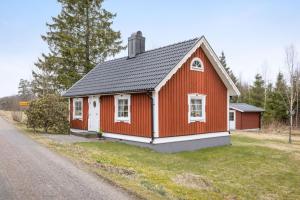 een rood-wit huis aan de kant van een weg bij Gulliga torpet in Vislanda