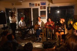 um grupo de pessoas sentadas numa sala com uma banda em INDÓMITO HOSTEL em San Carlos de Bariloche