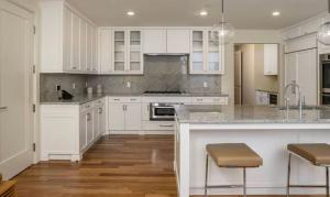 ロサンゼルスにあるLuxury apartmentsの白いキャビネットとスツール付きのキッチンアイランドが備わるアパートメントです。