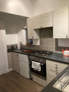 a kitchen with a stove and white cabinets at Coniston House Lancaster 3 bedrooms Parking and Garden in Lancaster