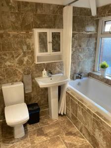ein Badezimmer mit einem WC, einem Waschbecken und einer Badewanne in der Unterkunft Coniston House Lancaster 3 bedrooms Parking and Garden in Lancaster