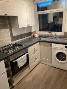 a kitchen with a stove and a washing machine at Coniston House Lancaster 3 bedrooms Parking and Garden in Lancaster