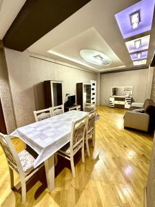 een eetkamer met een witte tafel en stoelen bij Xatai cozy apartment by Baku Housing in Baku