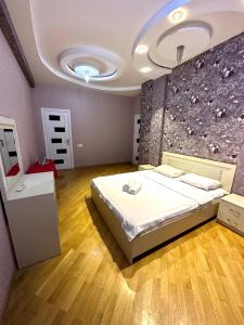 een slaapkamer met een bed en een muur met bloemen bij Xatai cozy apartment by Baku Housing in Baku