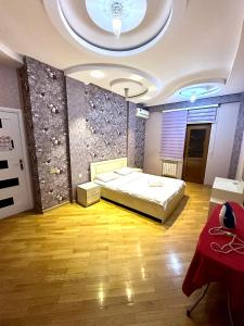 een slaapkamer met een bed in een kamer met een plafond bij Xatai cozy apartment by Baku Housing in Baku