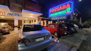 un estacionamiento con coches estacionados frente a un hotel en Pousada Ana do Forte, en Praia do Forte