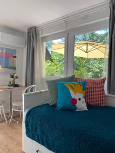 a bedroom with a bed with a window and a table at Szepihenő in Balatonszepezd