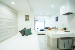 Habitación blanca con lavabo y cama en Sign Palace サインパレス en Kagoshima