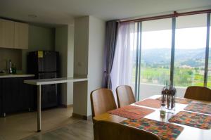 a kitchen and dining room with a table and a window at Apartahogar in Paipa
