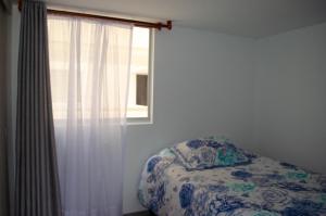 1 dormitorio con cama y ventana en Apartahogar en Paipa