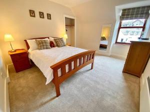 a bedroom with a large bed and a window at Bruachdryne Braemar Accommodation in Braemar