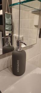 a black soap dispenser on a sink in a bathroom at la casa di amy - loft corvetto in Milan