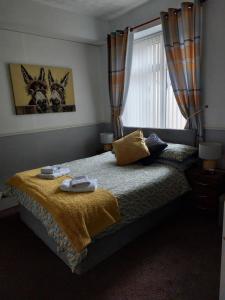 1 Schlafzimmer mit einem Bett mit einem Fenster und einer Tagesdecke in der Unterkunft Lynbar guesthouse in Blackpool