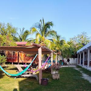 a resort with a hammock in a yard at Posada los abuelos in Holbox Island